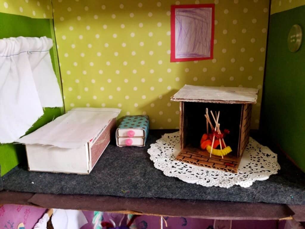 DIY dollhouse and furniture. fireplace, bed, dresser, and window pictured.