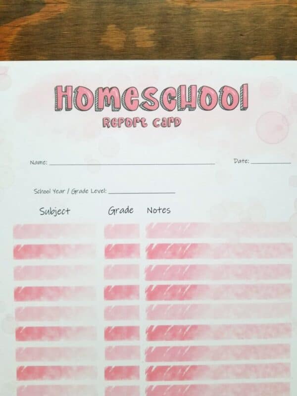 Homeschool report card has pink squares for writing in subjects, grades, and notes. pink bubbles decorate the page