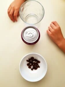 Supplies needed for at home science experiment include a glass, carbonated beverage, and raisins.