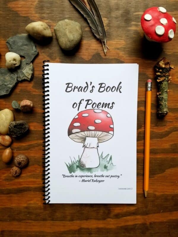 Customizable notebook with hand illustrated mushroom on the front cover. Personalize your notebook with font and text. Book shown is being used as a book of poems with an inspirational quote at the bottom edge of the cover.
