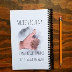 Custom left handed notebook comes with hand illustrated left hand thumbs up. Hand comes in light skin and dark skin tones. Customize the text on the title. This example shows it being used as a journal. Funny quote at the bottom of cover.