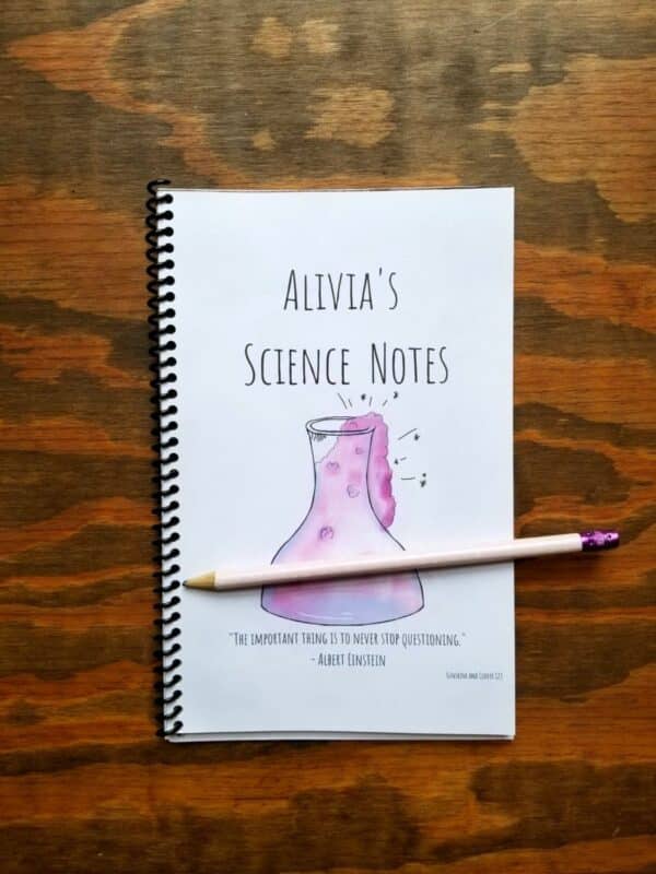 Notebook for science note taking has a hand illustrated science flask on it in bubbly pink and purple design.