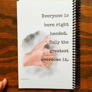funny left handed notebook contains a hand illustrated thumbs up picture as well as a funny saying. Spiral bound notebook contains spiral binding on the opposite side of usual as a funny gag for lefties.