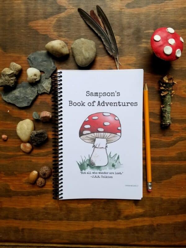 Spiral bound notebook with hand illustrated mushroom and customizable text and font. Notebook is half letter sized and has black spiral binding along the edge. White background on the cover with red mushroom and custom title and optional message or quote.