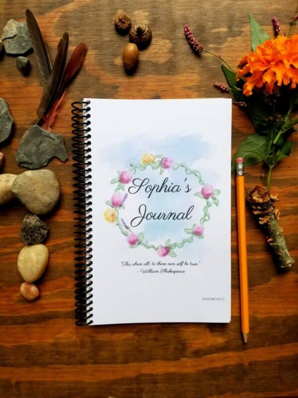 Personalized spiral bound notebook includes hand illustrated flower design and customization of font and text on the journal cover. Cursive style writing featured on this cover option.