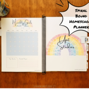 Spiral bound homeschool planner includes a unit studies planning section and a monthly planning section with undated calendars for 12 months. The homeschool planner has a rainbow theme with soft blue and pink accenting throughout.