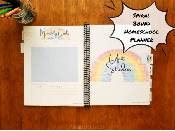 Spiral bound homeschool planner includes a unit studies planning section and a monthly planning section with undated calendars for 12 months. The homeschool planner has a rainbow theme with soft blue and pink accenting throughout.