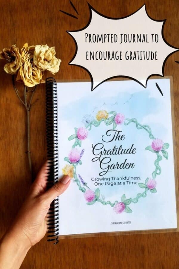 Prompted gratitude journal is titled the gratitude garden and has a hand illustrated flower circle encircling the title. Journal pages are shown printed out and spiral bound in US standard size paper.