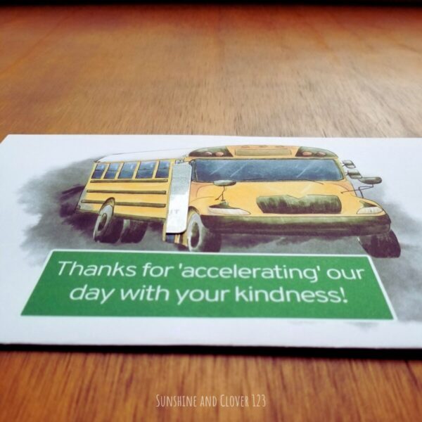 Gift card holder for school bus drivers. Hand illustrated school bus with white background has gift card emerging from the bus door. Has a green sign that reads "Thanks for accelerating our day with your kindness!".