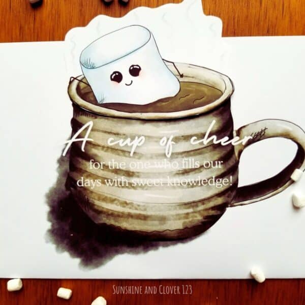 Handmade Christmas card for teachers, mentors, or tutors features a large puffy marshmallow smiling as floating in a cup of hot chocolate. Cup is grey with a handmade pottery style look to it and has wording over front of mug.