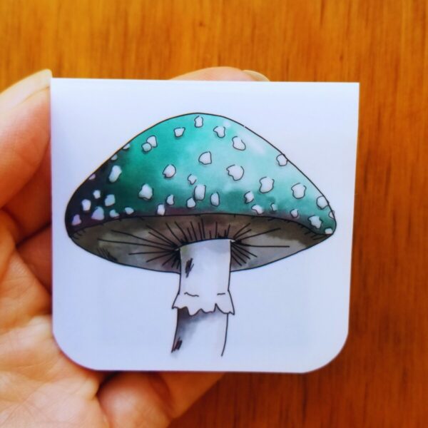 Unique magnetic bookmark displays a hand illustrated green mushroom with white spots.