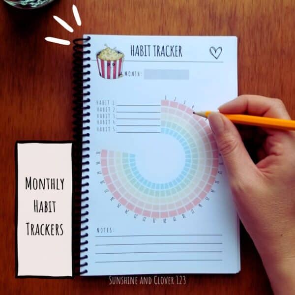 Monthly habit tracking pages are provided with a colorful circle design and hand illustrated kawaii style popcorn at the top of the page.