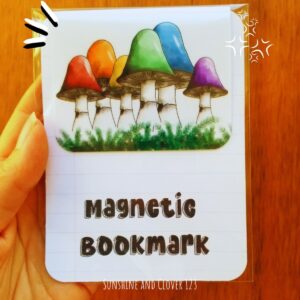 Magnetic bookmark with rainbow colored mushrooms set in a bed of moss.